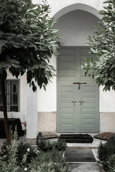 porta em verde pastel rodeado de plantas